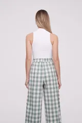 Top de punto acanalado color blanco, con cuello alto y diseño sin mangas, de corte ajustado al cuerpo.