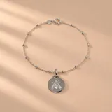 Pulsera de plata 925 con cadena de eslabones y pequeñas cuentas esféricas intercaladas, con un dije colgante en forma de medalla circular grabada con la figura de una abeja.
