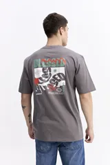 Remera de manga corta color celeste claro, con cuello redondo y estampado gráfico grande en la espalda con la palabra "BLESSED" y frases como "BE GRATEFUL EVERY MOMENT". Incluye el logo de la marca Mistral.