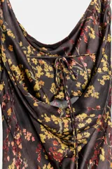 Vestido midi de viscosa con estampado floral sobre fondo oscuro. Presenta escote fluido tipo cowl neck, tirantes anchos y cierre lateral con cremallera oculta.