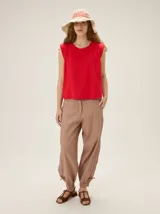 Pantalón de silueta relajada y moderna, color beige, con detalles de costuras y fruncidos ajustables en los tobillos.
