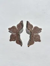 Par de aros dorados con forma de media flor, con detalle de strass negro y gancho de acero quirúrgico.