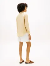 Camisa de lino puro color beige, de corte amplio y mangas largas, con cuello inglés, cierre frontal de botones y logo bordado en el pecho. Marca Tommy Hilfiger.