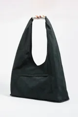 Bolso de hombro tipo shopper de nylon color verde oscuro, con estructura blanda y asa de piel. Presenta un asa superior con detalle de pelo sintético estampado (efecto vaca/marrón y blanco) y cierre de botón de presión. Lleva el logo metálico BIMBA Y LOLA en la parte inferior frontal.