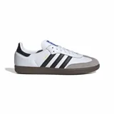 Championes Adidas Samba OG, color blanco con detalles en negro y gris. Diseño clásico de cuero con las tres tiras laterales en contraste y suela de goma marrón.