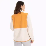 Campera polar color crema con paneles color naranja en la parte superior delantera y en el cuello. Cierre frontal con cremallera color naranja y bolsillos laterales con cierre.