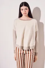 Sweater de punto color beige con mangas marrones y cuello y ruedo en azul marino.