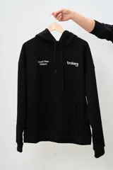 Canguro negro con capucha, cordones ajustables y bolsillo tipo canguro. Estampado frontal con el logo de la marca 'Brokers Wear' y la frase 'Good Time Makers'.