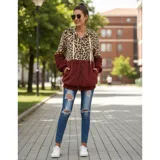 Campera tipo polar con cierre frontal, diseño combinado con estampado animal print en la parte superior y tejido de peluche blanco en la parte inferior. Cuenta con capucha con cordones ajustables y dos bolsillos frontales.