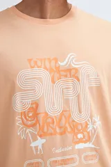 Camiseta de manga corta color salmón con estampado frontal estilo retro con temática de surf.