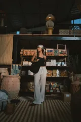 Pantalón de corte recto y tiro alto, confeccionado en lino color blanco. Presenta cierre frontal con botón y bolsillos laterales.