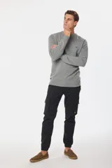 Pantalón cargo negro con bolsillos laterales con solapa y tobillos ajustados.