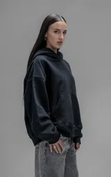 Hoodie oversize de corte crop, color negro, confeccionado en frisa gamuzada de algodón. Presenta capucha forrada, mangas largas con puños elásticos y bolsillo tipo canguro frontal.