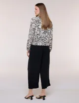 Camperita liviana de silueta entallada y largo a la cintura, con cuello camisero, cierre frontal de botones, mangas largas y bolsillos con solapa en el pecho. Presenta estampado animal print.