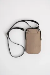 Bandolera porta celular color beige con correa larga negra ajustable.
