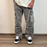 Pantalón de jean estilo cargo con corte baggy, color azul lavado. Presenta cuatro bolsillos laterales de gran tamaño con solapa y cierre de botones, diseño de pierna ancha y tiro medio.