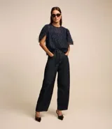 Blusa de chiffon azul marino con cuello redondo, mangas cortas con pliegues en los hombros y textura con felpas.