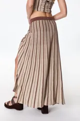 Falda larga de tejido de punto a rayas verticales color beige y marrón, con cintura marrón y abertura lateral.