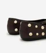 Zapatilla tipo bailarina color marrón con apliques de esferas metálicas doradas. Confeccionada en cuero sintético y sin cierre.
