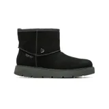 Bota corta Skechers de estilo casual, confeccionada en gamuza color negro con forro interior de lana. Presenta un diseño sin cordones con tecnología Slip-ins, suela de caucho resistente y detalle de dije metálico en forma de corazón en el lateral.