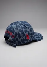 Gorra de béisbol con estampado animal print en tonos azules y grises, y bordado blanco en el frente. Cuenta con visera curva y ajuste regulable en la parte trasera.