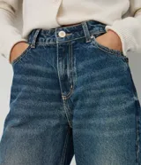Pantalón de jean premium de tiro medio con corte wide leg, de color azul, con pretina con pasacintos y bolsillos funcionales.