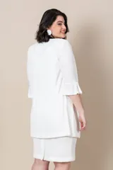 Vestido blanco con bordado de perlas y canutillos en el escote y túnica larga con tajos y ribete de satén.