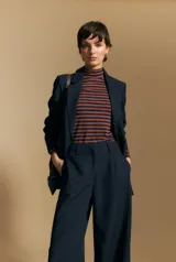 Pantalón de vestir negro de corte ancho y tiro alto, con silueta fluida y diseño minimalista.