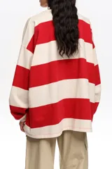 Remera manga larga oversize con diseño de rayas horizontales anchas rojas y blancas, cuello redondo y calce holgado.