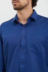 Camisa azul oscuro de manga larga con cuello abotonado y bolsillo en el pecho.