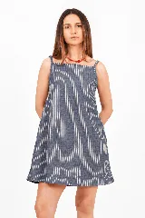 Vestido corto de lino a rayas, con silueta levemente evasé y calce relajado. Presenta escote recto y breteles finos con diseño de rayas verticales.