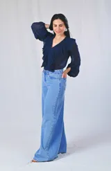 Camisa azul marino de mangas largas con volados plisados en el frente y escote en V.