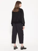 Pantalón negro de poplín con cintura elastizada, pierna ancha y bolsillos laterales. Corte cropped.
