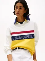 Chomba de rugby Tommy Hilfiger Sailing, unisex, de corte amplio y hombros caídos. Diseño color block blanco, amarillo y azul, con logo de la marca bordado en el pecho.