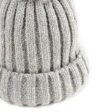 Gorro de lana gris con textura acanalada y pompón en la parte superior.