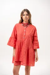 Vestido corto coral de broderie, con cuello camisero, cierre frontal de botones, mangas tres cuartos con volados y diseño escalonado en la falda.