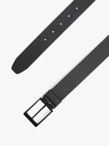 Cinturón reversible de cuero con hebilla metálica negra y detalle de logo de la marca. Diseño versátil con acabado liso.