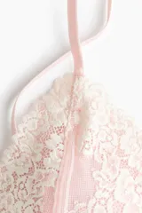 Soutien de encaje y malla en tono rosado, con breteles ajustables y copas suaves sin aros con apliques florales.