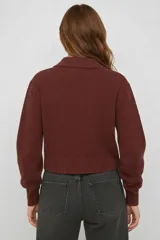 Saco de punto color bordó con cuello tipo camisa, cierre frontal con botones y mangas largas con puños acanalados.