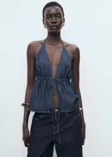 Pantalón de jean estilo wide leg, de tiro bajo y corte largo, con diseño de cinco bolsillos, trabillas para cinturón y cierre frontal con botón y cremallera.