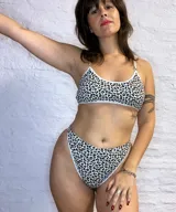 Conjunto de lencería de dos piezas confeccionado en algodón con estampado animal print. Incluye un corpiño tipo top con escote redondo y breteles finos regulables, y una bombacha tipo colaless de tiro alto con detalle cruzado en los laterales.