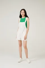 Enterito corto blanco con breteles anchos, escote recto con detalle de flecos y bolsillos delanteros.