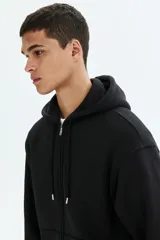 Campera con capucha de felpa de peso medio con interior cepillado suave. Presenta hombros caídos, cierre frontal, bolsillos tipo canguro y terminaciones en punto acanalado en puños y bajo.