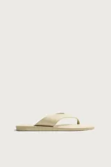Sandalias de cuero color beige con acabado abatanado, diseño de dos tiras en el empeine tipo chancla y suela plana a tono.
