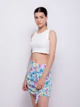 Minifalda estampada con flores en tonos celeste, azul, rosa y amarillo, con volados en el frente y cierre invisible en la parte trasera.