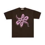 Remera de manga corta, corte regular fit, color marrón oscuro con un gran estampado frontal en rosa pálido que simula un logo estilizado o un símbolo abstracto.