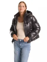 Campera puffer de Michael Kors con acabado brillante, diseño capitoneado, capucha integrada con cordones de ajuste, cuello alto, cierre frontal con tirador metálico y puños elásticos.