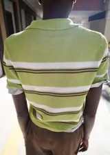 Chaleco de punto de manga corta con rayas horizontales en tonos verde, blanco y marrón, cuello camisero y cierre frontal parcial de botones.