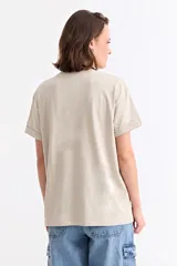 Remera de algodón color beige con cuello redondo y mangas cortas con dobladillo. Presenta un estampado frontal rectangular en color rosa con el texto en relieve 'PINK IS ALWAYS AN OPTION'.