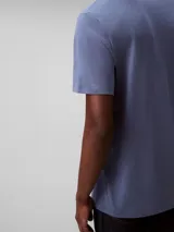 Remera de manga corta color azul, hecha de algodón liso, con cuello redondo y el monograma de Calvin Klein bordado en rojo en el pecho.